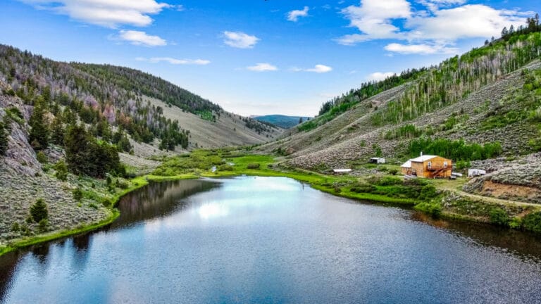 Breathtaking View of Mouflon Lodge, featuring Mountain Lodge Comfort, and a beautiful Trout-filled Reservoir, surrounded by San Juan Mountains- a Colorado Ranch For Sale